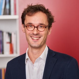 Félix Krawatzek, Politikwissenschaftler, strahlt in die Kamera.