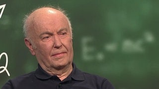 Mit 81 Jahren arbeitet Volker Hoffmann noch als Lehrer und unterrichtet unter anderem Mathe und Physik. Im Hintergrund ist eine Schultafel zu sehen.