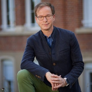 Unternehmer und Sterbebegleiter Markus Müller schaut freundlich in die Kamera. | Vom Top-Manager zum Sterbebegleiter | SWR1 Leute
