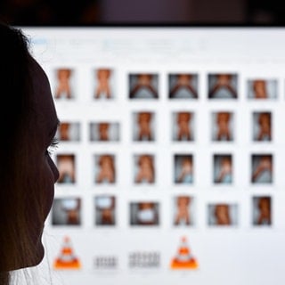 Symbolbild: Eine Person sitzt im Dunkeln vor einem Bildschirmcomputer.