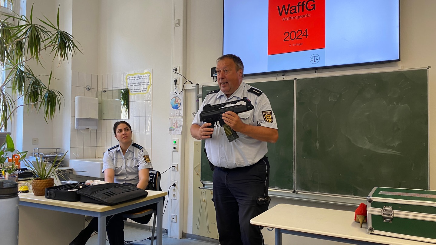Ein Mannheimer Polizist zeigt in einem Klassenraum der Tulla-Realschule in Mannheim eine Softairwaffe
