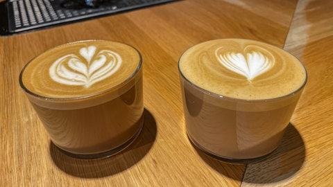 Zwei Gläser Cappuccino mit Latte Art. Martin Lai von Südhang Kaffee in Tübingen. Mit einer Holzkuh möchte er auf ungerechte, unterschiedliche Besteuerung von Kuhmilch und Hafermilch aufmerksam machen. (Foto: SWR, Katharina Kregel) Zwei Gläser Cappuccino mit Latte Art. Martin Lai von Südhang Kaffee in Tübingen. Mit einer Holzkuh möchte er auf ungerechte, unterschiedliche Besteuerung von Kuhmilch und Hafermilch aufmerksam machen.