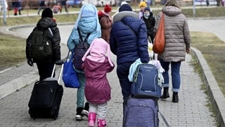 Geflüchtete Menschen laufen auf der Straße.