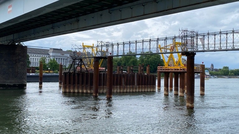 Die Pfaffendorfer Brücke in Koblenz wird neu gebaut - aus dem Wasser ragen Metallgestelle.