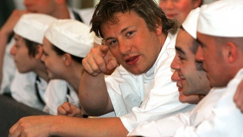 Jamie Oliver zeigt in einer weißen Kochjacke in die Kamera (Foto: IMAGO, IMAGO/FAMOUS) Jamie Oliver zeigt in einer weißen Kochjacke in die Kamera