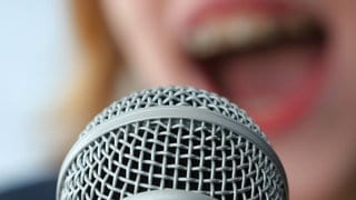 Ein singender Mund vor einem Mikrofon