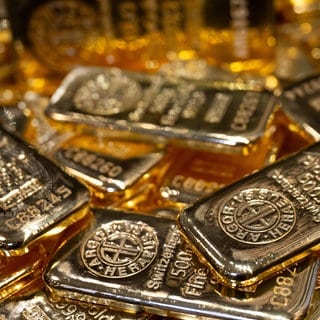 Goldbarren in unterschiedlicher Größe liegen auf einem Tisch