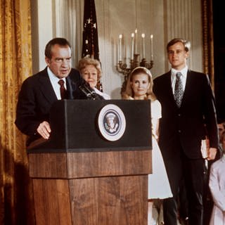 Der Republikaner Richard Nixon (Mitte) verabschiedet sich nach seiner Rücktrittserklärung von dem Stab des Weißen Hauses und den Mitgliedern seines Kabinetts. Links Tochter Julie mit ihrem Ehemann David Eisenhower, rechts neben ihm seine Gattin Pat und Tochter Patricia mit deren Ehemann Edward Cox. Um einer Amtsenthebung (Impeachment) wegen der "Watergate-Affäre" zu entgehen, war Nixon am 9. August 1974 als erster Präsident der USA von seinem Amt zurückgetreten.