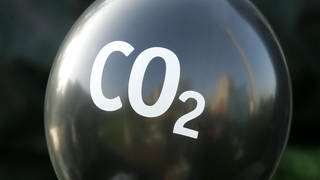 Schwarzer Ballon mit weißer Aufschrift CO2: Hermann Flohn, Meteorologe und Klimaforscher, beschrieb die Möglichkeit eines menschengemachten Klimawandels bereits 1941 in seiner Habilitation