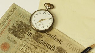 Taschenuhr auf einer alten 1000-Mark-Banknote