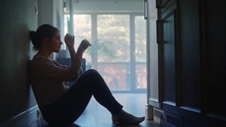 Eine Frau sitzt im Flur