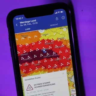 Wetterwarnunf auf einem Handy. KI-Modelle wie Microsofts „Aurora“ liefern teils bessere Wetterprognosen als klassische Methoden. Doch wie gut sind sie wirklich? Und was sagen Fachleute dazu?
